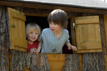 Berlin  Kinder schauen aus dem Fenster eines Baumhauses