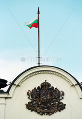 Staatswappen und Nationalflagge am Gebaeude des Bulgarischen Parlaments in Sofia