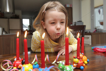 Handewitt  Deutschland  ein Maedchen mit Kerzen und Geschenken an seinem sechsten Geburtstag