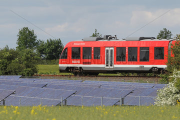 Husby  Deutschland  Regionalzug der Deutschen Bahn faehrt an Solarkraftanlagen vorbei