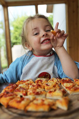 Handewitt  Deutschland  ein Maedchen isst eine kleingeschnittene selbst gemachte Pizza