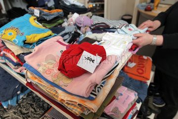 Flensburg  Deutschland  eine Frau sucht nach Kinderkleidung im Sozialkaufhaus Mehrwert
