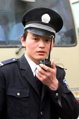 Shanghai  Sicherheitsbeamter spricht in sein Funkgeraet