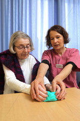 Flensburg  Deutschland  Ergotherapeutin macht mit einer Patientin Uebungen mit Knetgummi