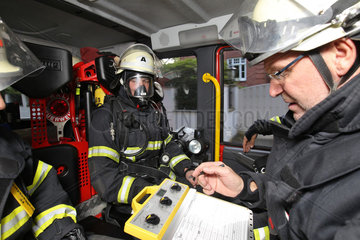 Grosshansdorf  Deutschland  Feuerwehrmaenner in einem Einsatzfahrzeug