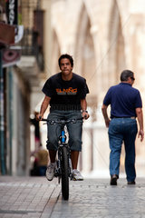 Leon  Spanien  Jugendlicher faehrt mit dem Fahrrad durch die Strassen
