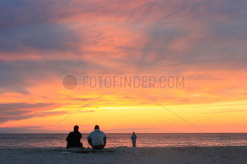 Hvide Sande  Daenemark  Menschen beobachten den Sonnenuntergang am Meer