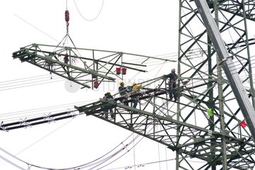 Bad Schandau  Deutschland  Arbeiter bringen eine Traverse an einem Strommasten an