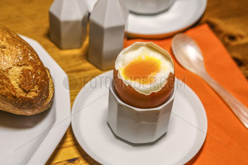 Fruehstuecksei in einem Eierbecher mit weichem Dotter