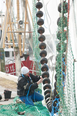 Friedrichskoog  Deutschland  ein Fischer bessert seine Netze im Hafen aus