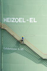 Schoenefeld  Deutschland  ein Mann steigt eine Treppe an einem Heizoeltank hinauf