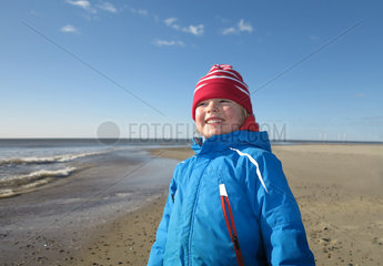 Hvide Sande  Daenemark  ein Junge mit einer roten Muetze am Strand