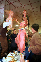 Eine tuerkische Bauchtaenzerin tanzt auf dem Tisch