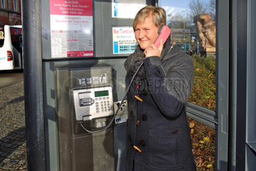 Flensburg  Deutschland  eine Frau benutzt eine Telefonzelle