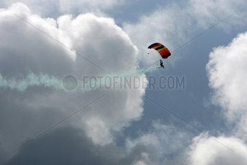Cuxhaven  Deutschland  Fallschirmspringer zieht in der Luft eine Rauchfahne hinter sich her