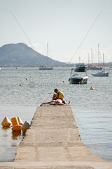 Port de Pollenca  Mallorca  Spanien  Badegaeste auf einem Bootssteg am Strand von Port de Pollenca