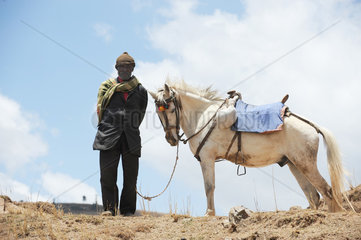 Mangudo  Aethiopien  ein Bauer mit seinem Pferd auf einem Feld