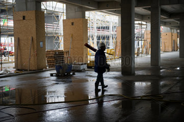 Schoenefeld  Deutschland  ein Arbeiter mit einem Besen auf der BBI Grossbaustelle