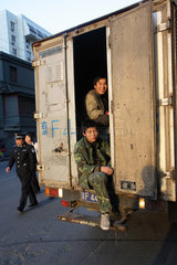 Peking  zwei junge Chinesen auf der Ladeflaeche eines LKW