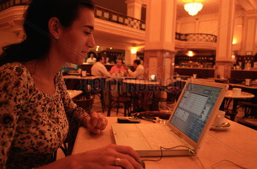 Frau im Cafe vor einem Laptop