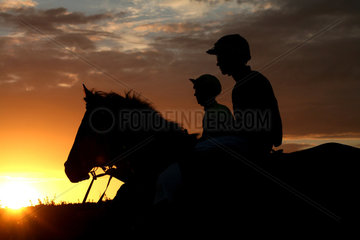 Bad Doberan  Deutschland  Silhouette  Jockeys auf ihren Pferden bei Sonnenuntergang