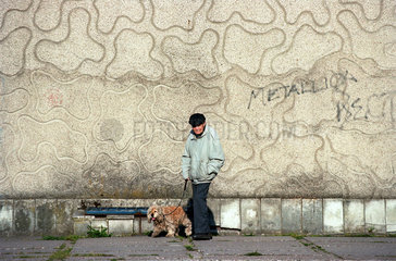 Alter Mann mit Hund an einer Mauer  Kaliningrad  Russland
