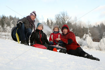Ingatorp  Schweden  Familie sitzt froehlich im Schnee