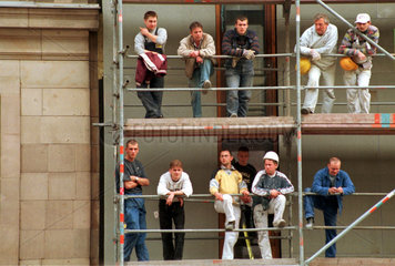 Bauarbeiter auf einem Geruest an einer Hausfassade