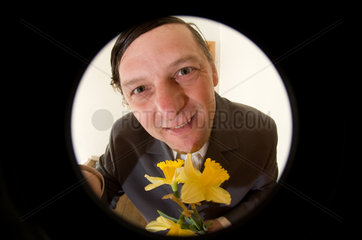Freiburg  Deutschand  Mann klingelt mit Blumen an der Tuer