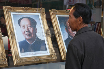 Peking  ein Mann schaut auf Mao-Portraet