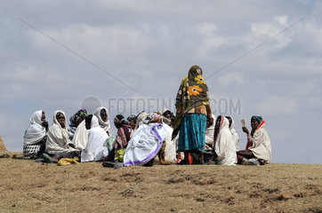 Mangudo  Aethiopien  Frauen und Maedchen sitzen auf dem Feld zusammen