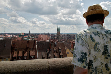 Nuernberg  Deutschland  Tourist mit Strohhut schaut auf die Altstadt