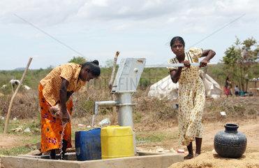 Vakaneri  Sri Lanka  zwei Frauen waschen Waesche an einer Wasserpumpe