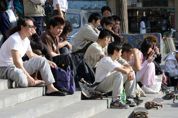 Peking  Leute schauen Skateboardfahrern zu