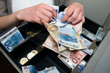 Berlin  Deutschland  Angestellte sortiert Geld in die Kasse