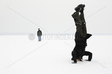 Berlin  Deutschland  Frau macht einen Kopfstand im Schnee