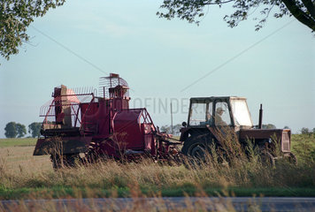 Bauer faehrt mit seinem Traktor ueber das Feld  Polen