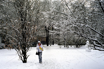Maedchen isst Chips bei einem Winterspaziergang in einem Park  Posen  Polen