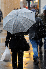 Berlin  Deutschland  Passanten mit Regenschirm bei Schneeregen