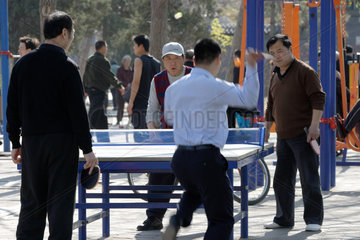 Peking  Maenner spielen im Park Tischtennis