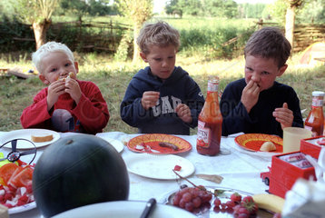 Kinder essen Gegrilltes