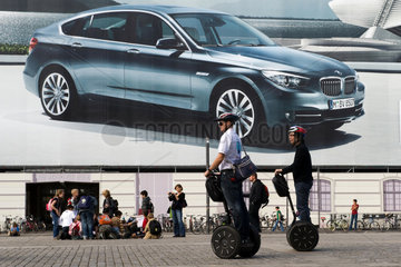 Berlin  Deutschland  Elektroroller Segway vor einem Grossplakat von BMW