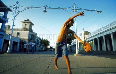 Ein Kind spielt in Kuba Baseball auf der Strasse