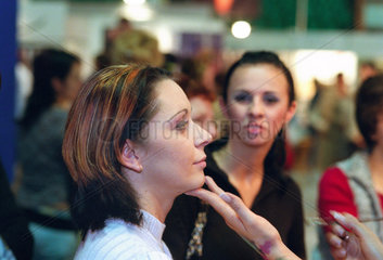 Eine Frau wird geschminkt bei Kosmetika- und Frisurenmesse in Poznan  Polen