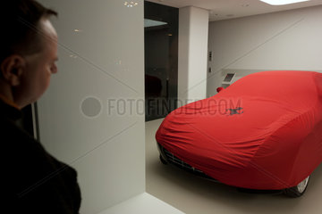 Warschau  Polen  Mann betrachtet abgedeckten Ferrari in einem Schaufenster