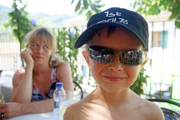 Valldemossa  Junge mit Sonnenbrille im Portrait  Mutter im Hintergrund