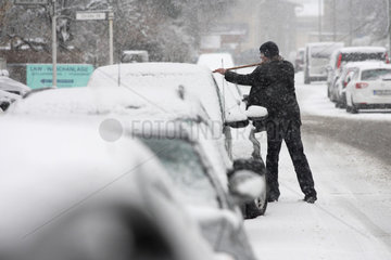 Berlin  Deutschland  ein Mann befreit sein Auto von Schnee
