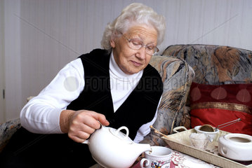 Nauen  Deutschland  eine Rentnerin giesst sich Tee ein