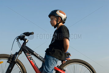 Freiburg im Breisgau  8-jaehriger Junge sitzt auf seinem Mountainbike
