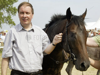 Dr. Steffen Pfennigwerth mit seinem Pferd Austrian im Portrait auf der Galopprennbahn